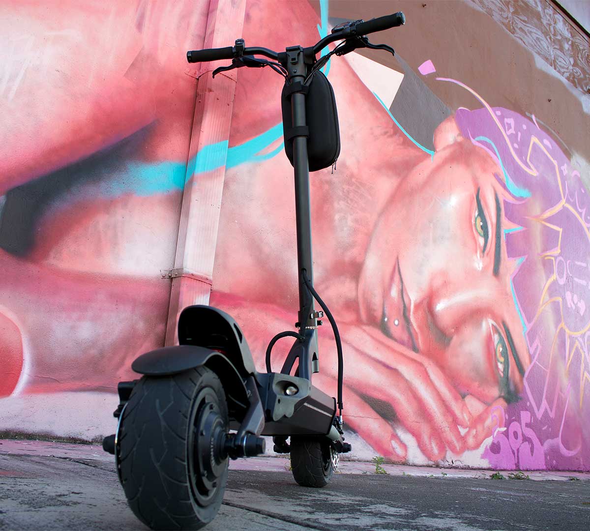 A sleek electric scooter stands before a striking street mural, capturing the essence of electric scooters as a part of the global movement towards sustainable urban living.