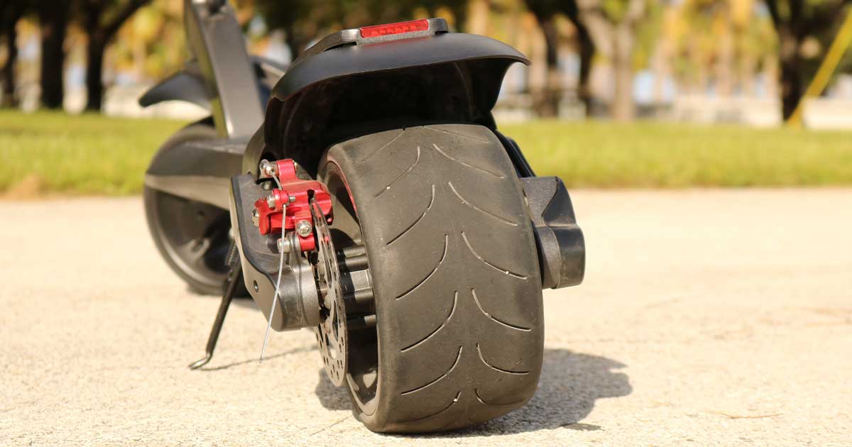 Close - up of an electric scooter'swheel showing tread detail, emphasizing the importance of tire maintenance during winter.