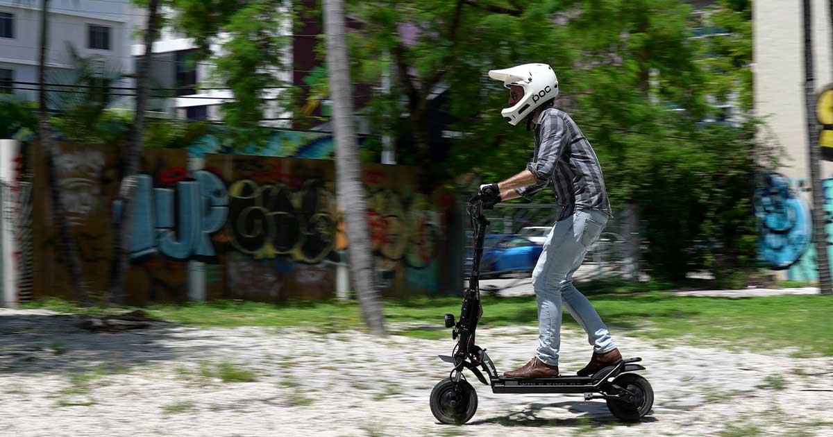 A rider in motion on a sleek electric scooter, wearing a full-face helmet for safety, embodying the competitive spirit of electric scooter racing.