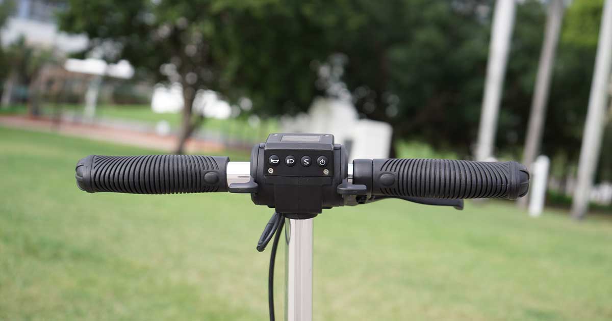 Close-up of an electric scooter's handlebars and controls, representing the intricate technology that has propelled the electric scooter from a simple toy to a sophisticated transportation device.