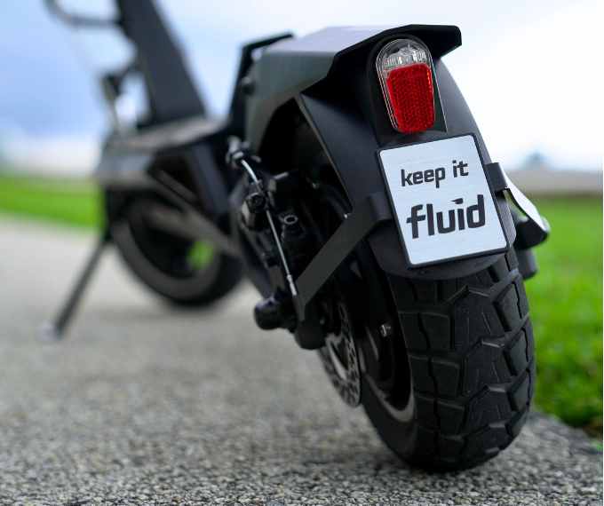 Close up shot of Electric Scooter Wheel with a Keep it Fluid Text 