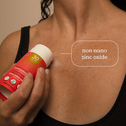 Woman applying ATTITUDE plastic free sunscreen stick made with zinc oxyde non nano