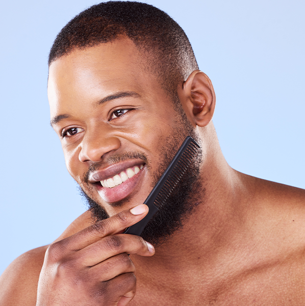 A black man combing his coily beard