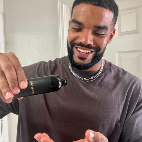 a smiling man pouring a shaving gel