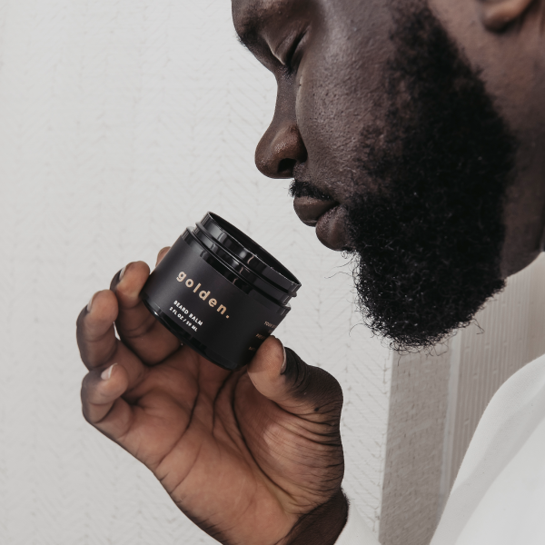 A man smelling Golden Grooming beard balm