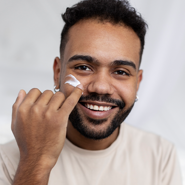 A man of color applying a moisturizer