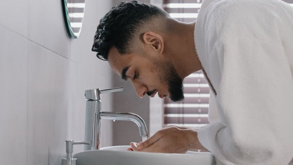 man washing off the beard balm