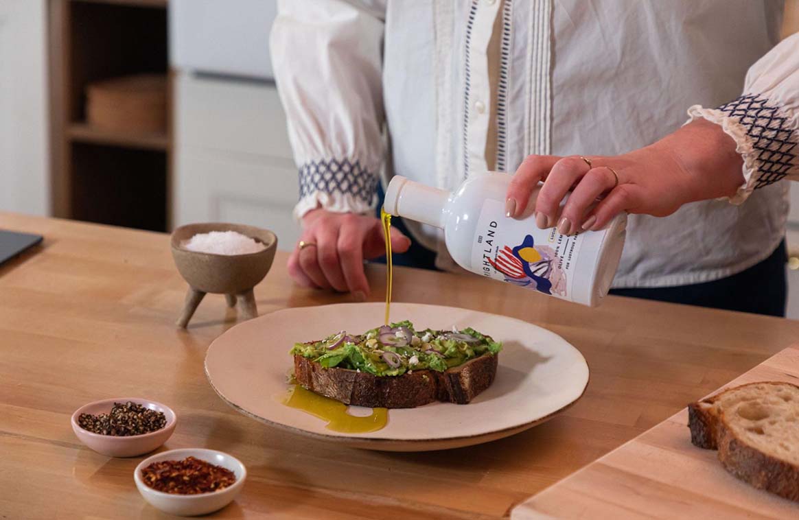 pouring olive oil over toast