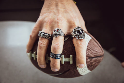 Man holding football wearing rings.