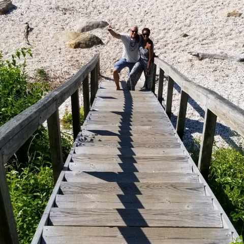 Couple standing at the bottom of a staircase on the beach 