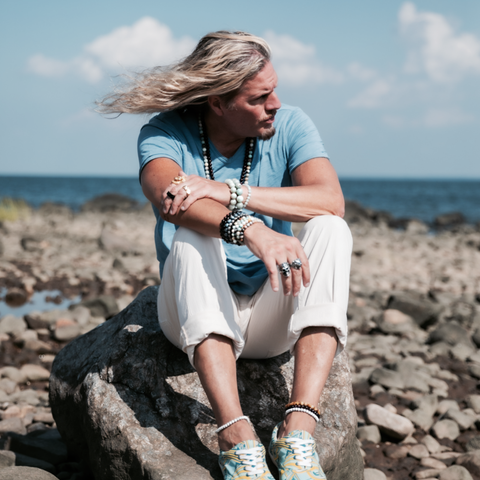 Male sitting on beach rock pondering