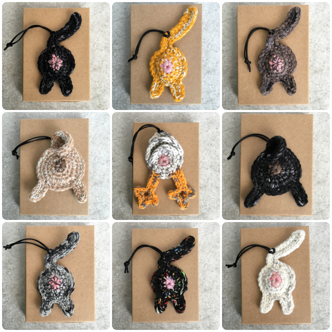 collage of cat, pug, and chicken butt ornaments in a variety of colors, all on Kraft boxes