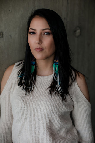 Girl with long black hair with a white top with shoulders exposed