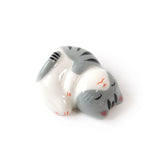 porte-baguettes en forme de petit chat endormi tigré gris et noir