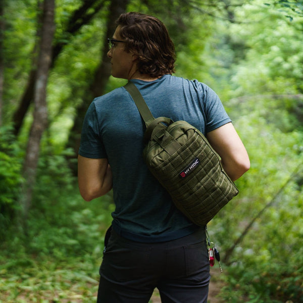 man carrying first "My Medic" first aid kit on back with strap