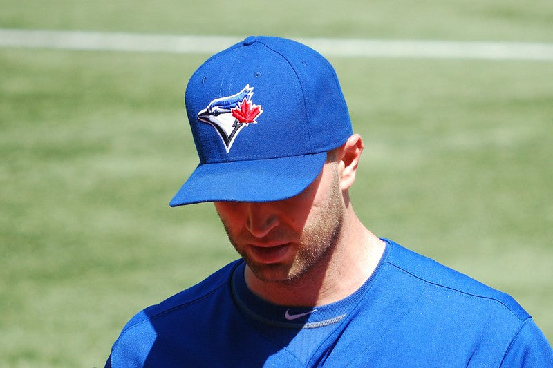c – Imagem de um jogador de basebol utilizando um boné padrão do uniforme do time.