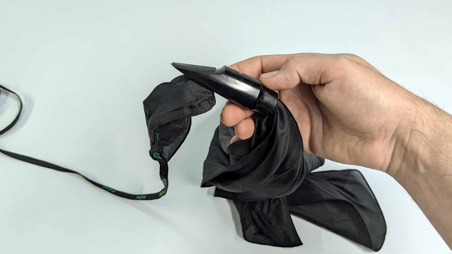 A silk swab cleaning a saxophone mouthpiece.