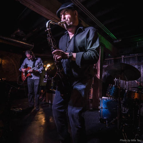 Saxophonist David Halliday playing tenor saxophone on stage. David approves of Key Leaves care products.