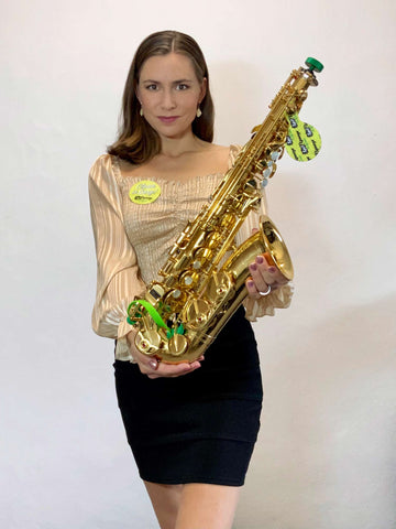 Czech sax player Katerina Palikova holding her alto saxophone with Key Leaves care products