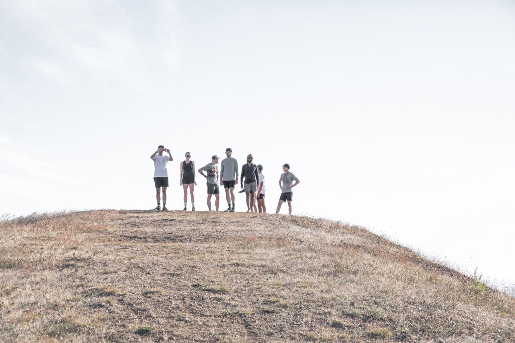 group of runners standing on top of hill