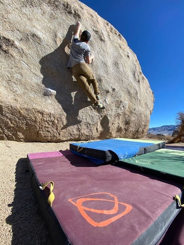 Climber on the Tut Boulder in the Buttermilks, using Asana Crash Pads. 