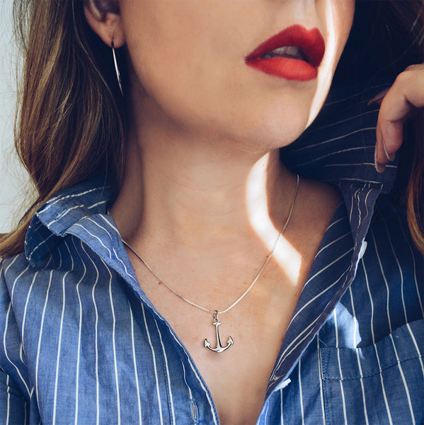 Anchor pendant with box link chain worn with button down shirt.