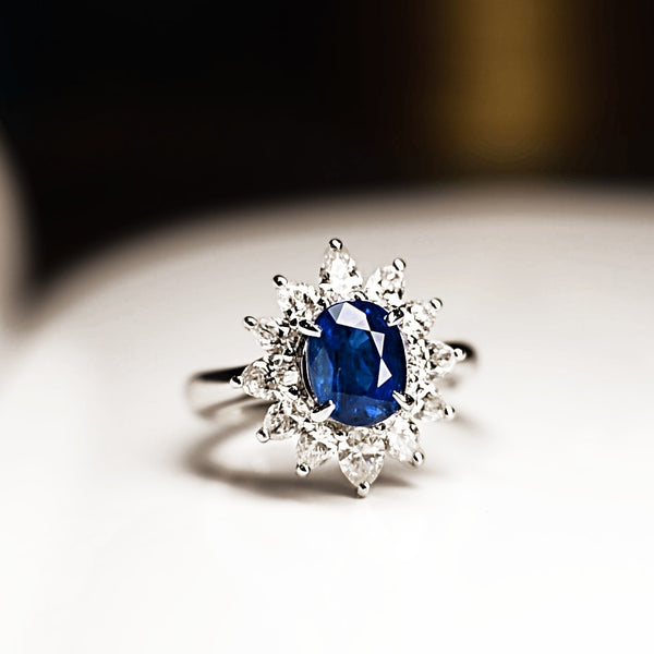 Floral petal inspired vintage ring with blue sapphire and diamond accents.