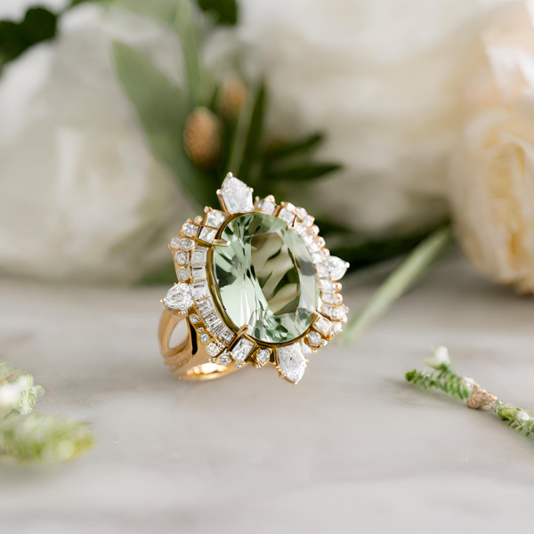 Ornate vintage style ring with white baguette diamond accents and green sapphire centre in yellow gold.