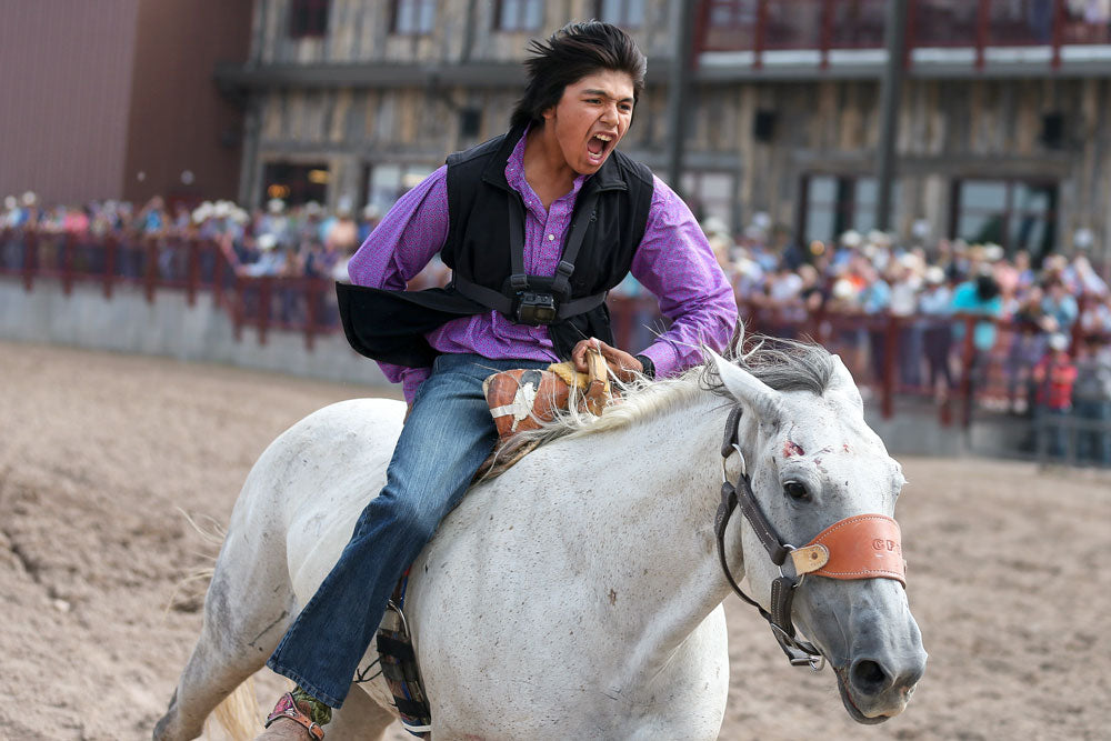 Olsen Meanus screams as he rides his horse toward the finish line to win the wild horse race. MICHAEL CUMMO / WYOMING TRIBUNE EAGLE