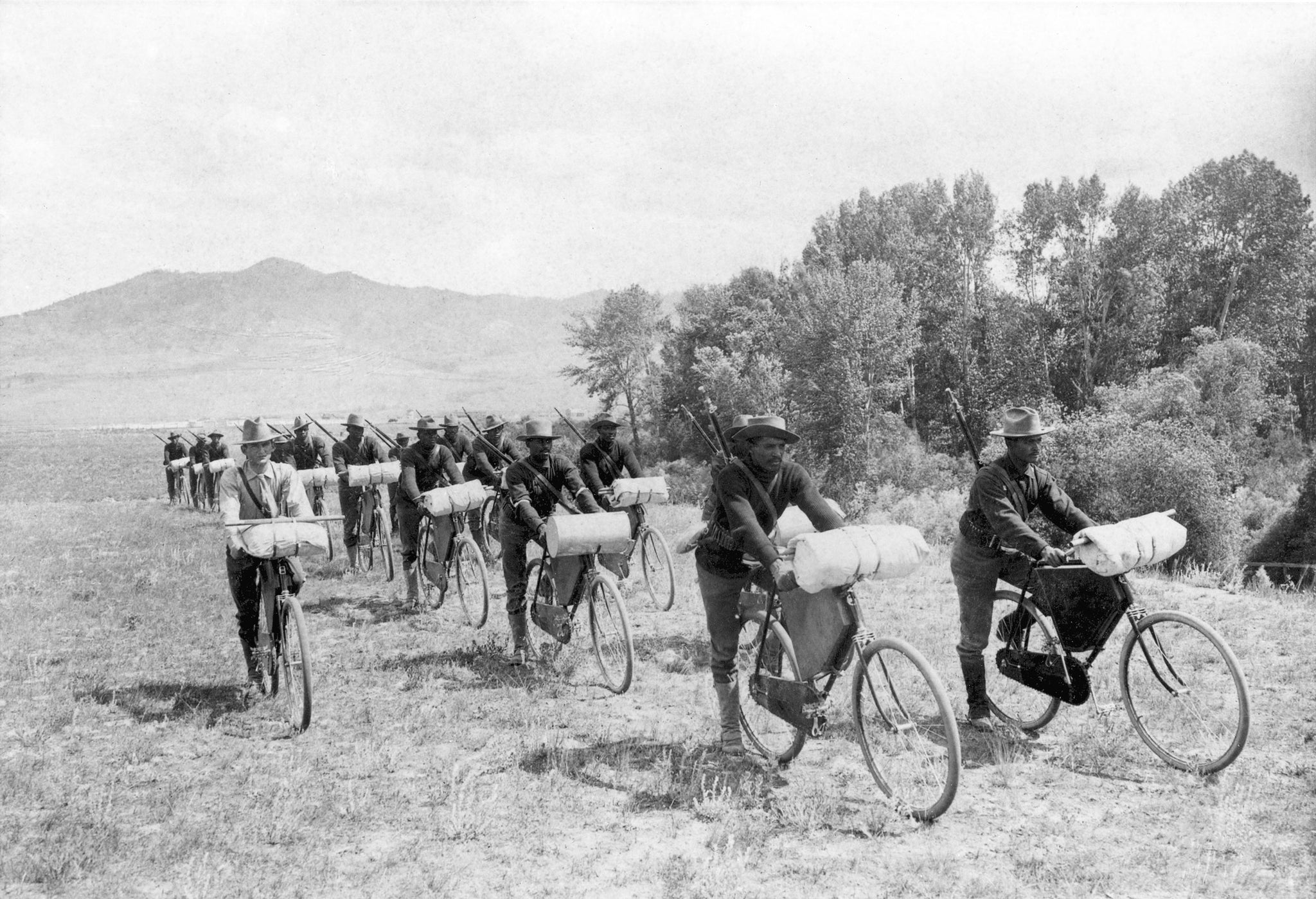 Members of the U.S. Army 25th Infantry Bicycle Corps stationed at Fort Missoula, 1897. Lt. James A. Moss is riding on the left beside the two rows of soldiers. -- Image 73-0031, Courtesy Mansfield Library Archives, University of Montana