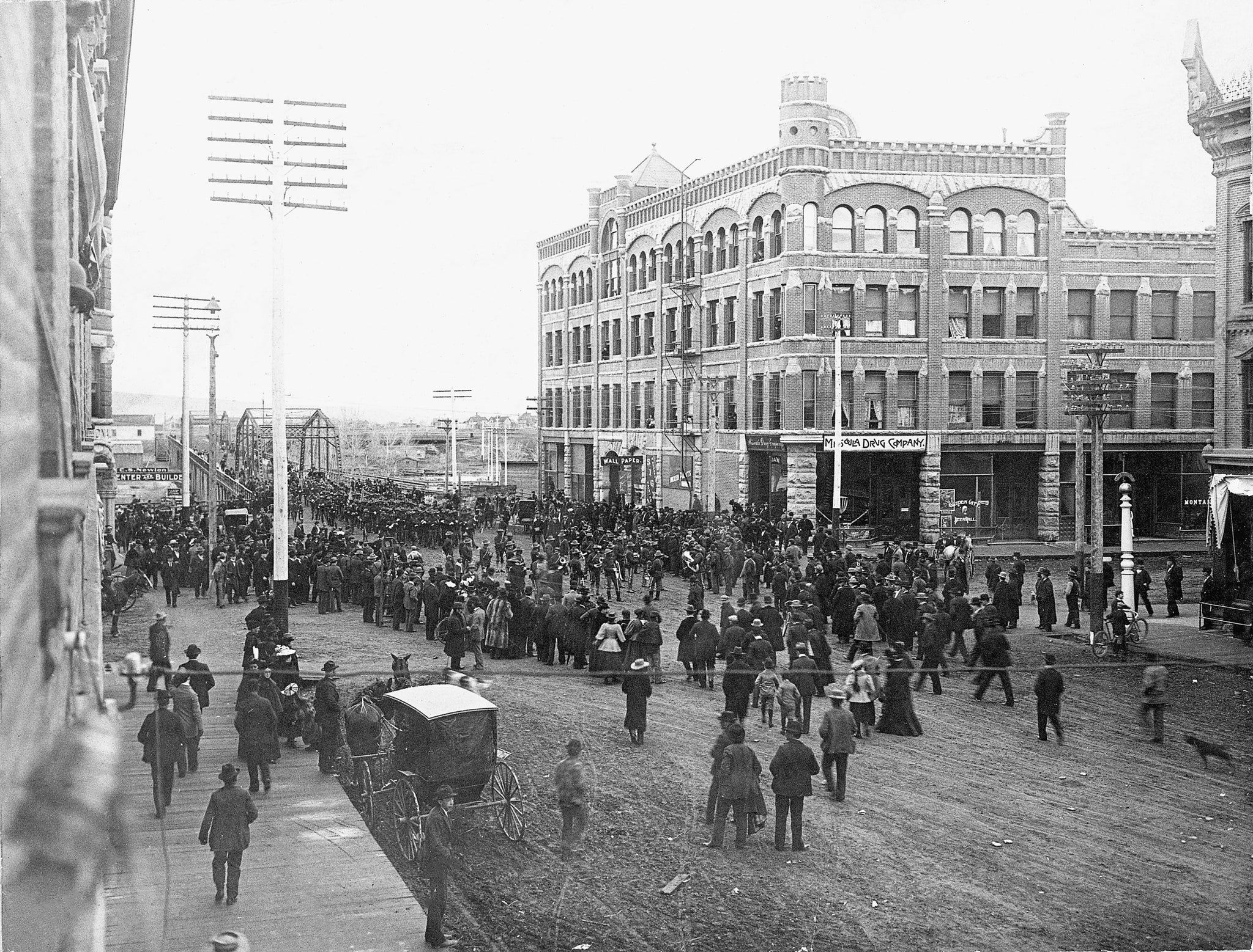 Crowd watching the departure of the United States Army’s 25th Infantry across Higgins Bridge in Missoula, April 10, 1898. Headed to Tampa, Florida, they were the first regiment to be active for the Spanish-American War. The Hammond Building is visible in the background. -- Image 76-0200, Courtesy Mansfield Library Archives, University of Montana