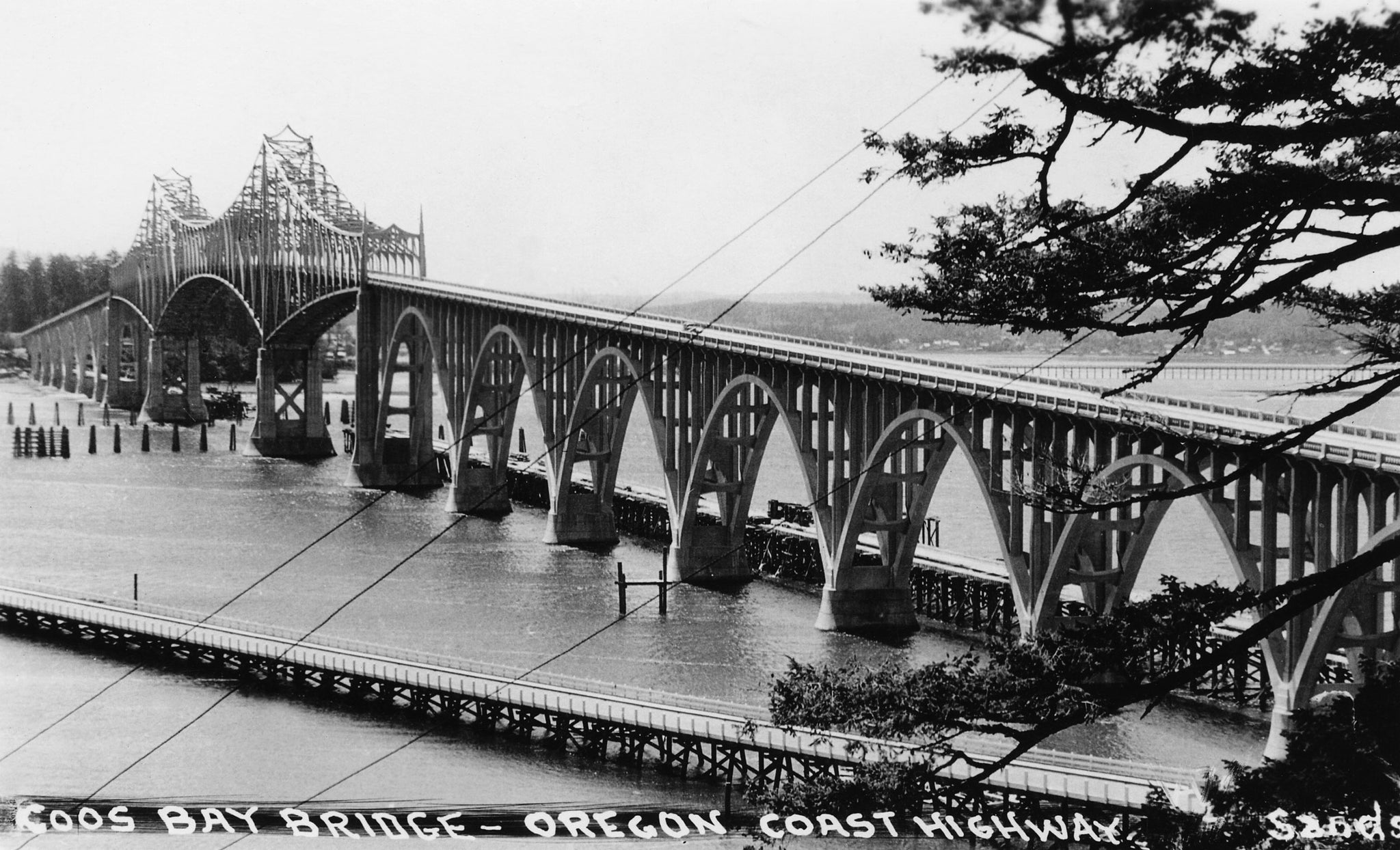 These photos of the completed Coos Bay Bridge in North Bend were both taken from un-mailed and undated postcards from the archives of the Coos History Museum. The photos likely date sometime shortly after completion of the span in 1936. The bridge, extending U.S. Route 101 through North Bend, was renamed the Conde B. McCullough Memorial Bridge in 1947 for its designer. The project was funded largely by the Depression-era Public Works Administration. The bridge was placed on the National Register of Historic Places in 2005. -- COOS HISTORY MUSEUM & MARITIME COLLECTION / 986-14.2
