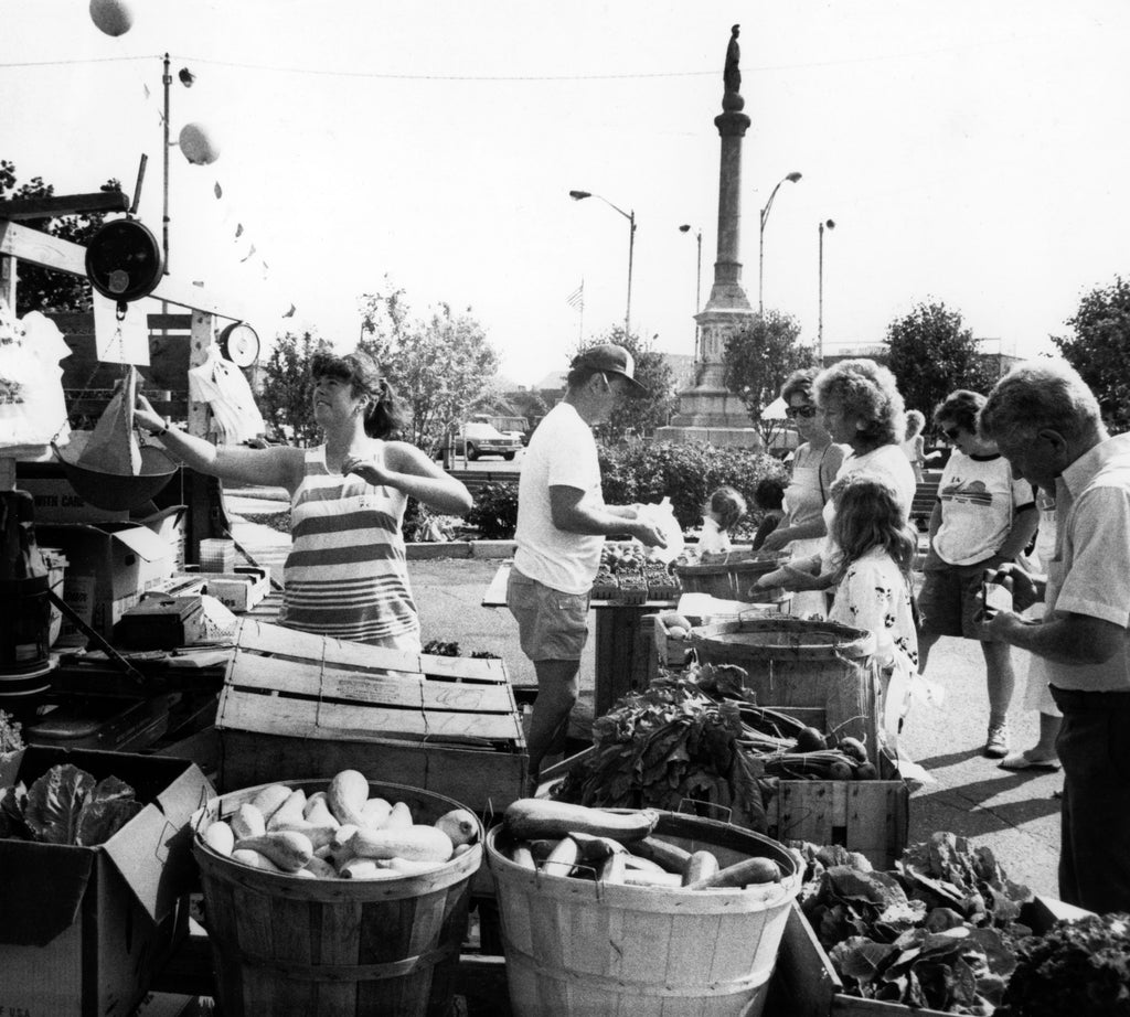 Cathy Haynes, left, is weighing items and Bill Clark is helping customers at the Clark Farm stand at the Peabody Farmers Market in July 1989. -- Courtesy The Salem News