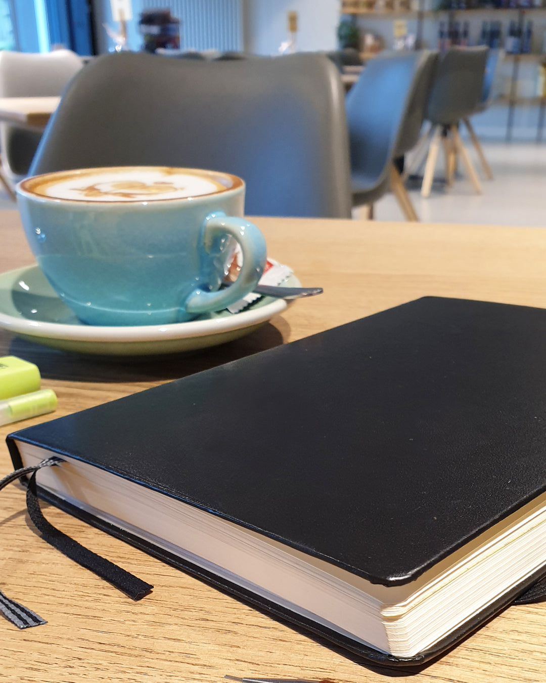 Coffee in the background with a bullet journal in the front