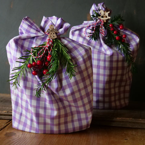 Gifts wrapped in reused fabric and Christmas tree branches/holly 
