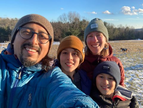 Picture of my family all smiling with sun on our faces, in a field with snow.