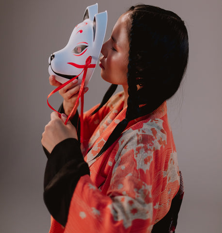 Japanese lady holding a kitsune mask