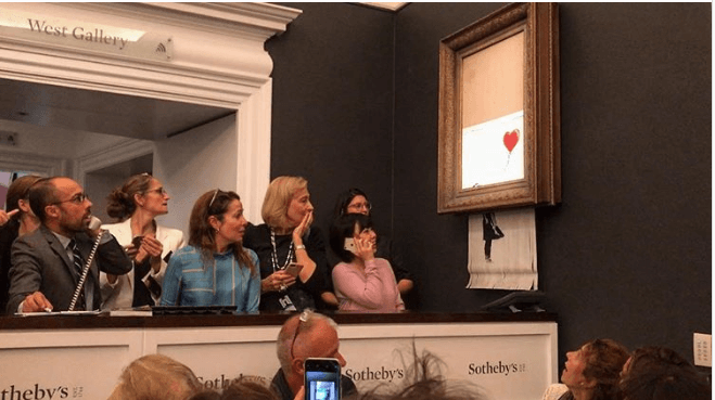 Foto de la pieza "La chica con el vestido" de Banksy siendo destrozada en una subasta de Sotheby's