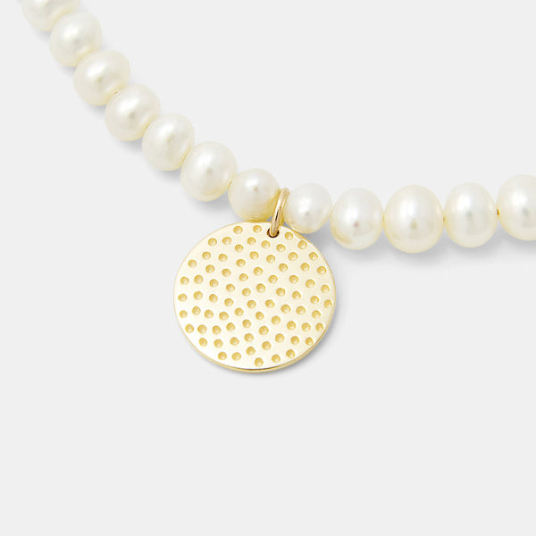 Solid gold pendant on pearl necklace