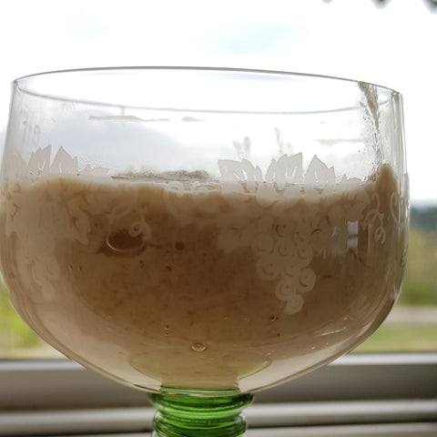 glass on windowsill with sourdough starter