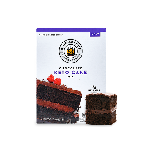 White box of King Arthur Baking Company Keto Chocolate Cake Mix on a white background, with a slice of keto chocolate cake with frosting in the center