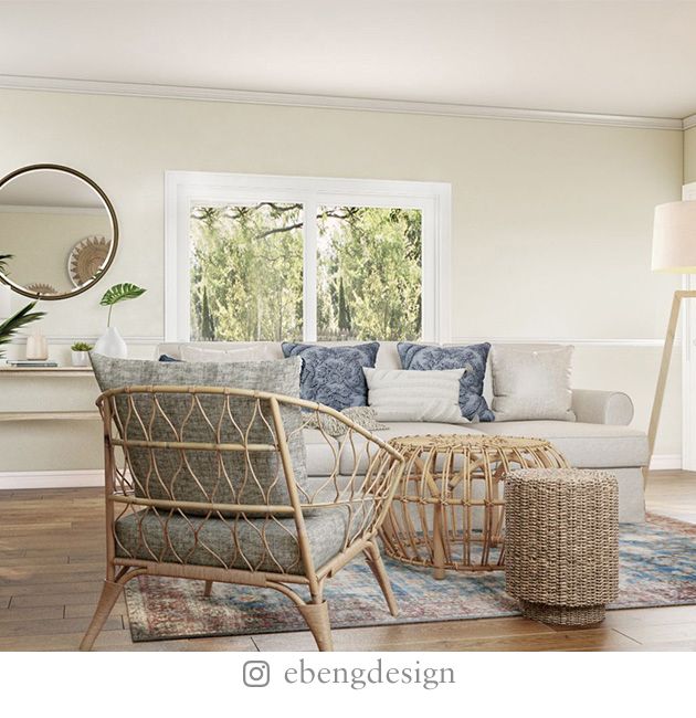 Boho living room with rattan chairs and coffee table, white sofa, lamp, stone fireplace, and round mirror.