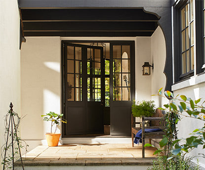 A beige stucco house with a brown front doorway.