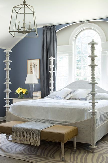 A master bedroom with gray-blue walls is complemented by a white angled ceiling.