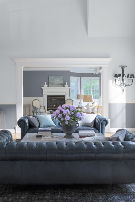 A serene living room in a combination of white and gray paint features two large leather couches.