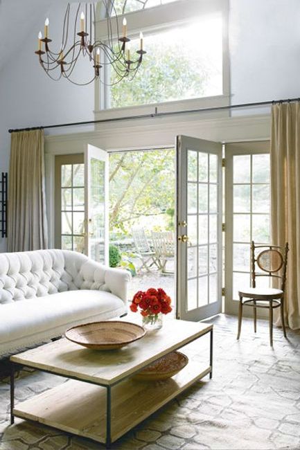 Light filled living room with elegant chandelier and high windows