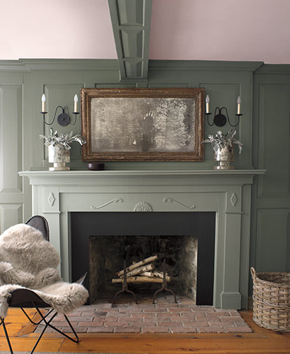 Olive green-painted walls with a light pink-painted ceiling and a muted green fireplace mantle.