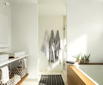 Bathroom painted in Chantilly Lace OC-65 featuring a wooden bathtub and striped rug.