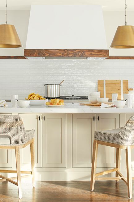 A white kitchen with island painted in Gentle Cream OC-96 and walls painted in Timid White OC-39.