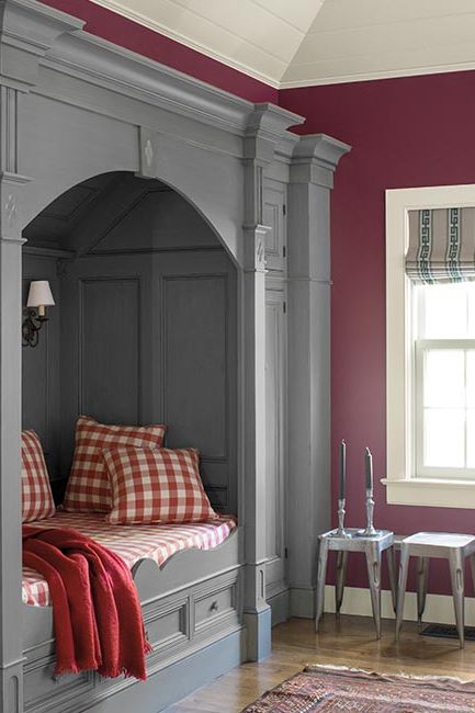 A crisp magenta room with a gray paneled & trim built in bed with red gingham bedding.